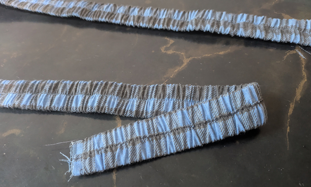 Shoulder strap made with gathered fabric and an elastic piece inside 